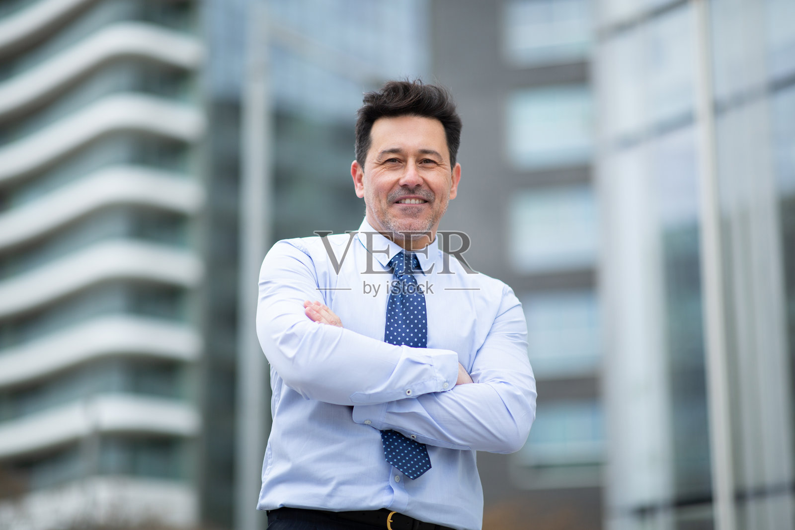 自信的成熟商人在外面双臂交叉站立照片摄影图片