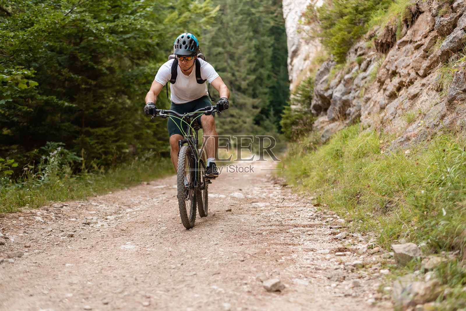专业山地自行车骑手在越野小径上骑行,进行户外冒险运动。照片摄影图片