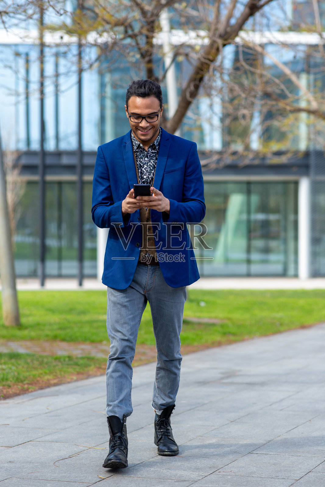 时尚年轻人在城市中走路时使用手机照片摄影图片