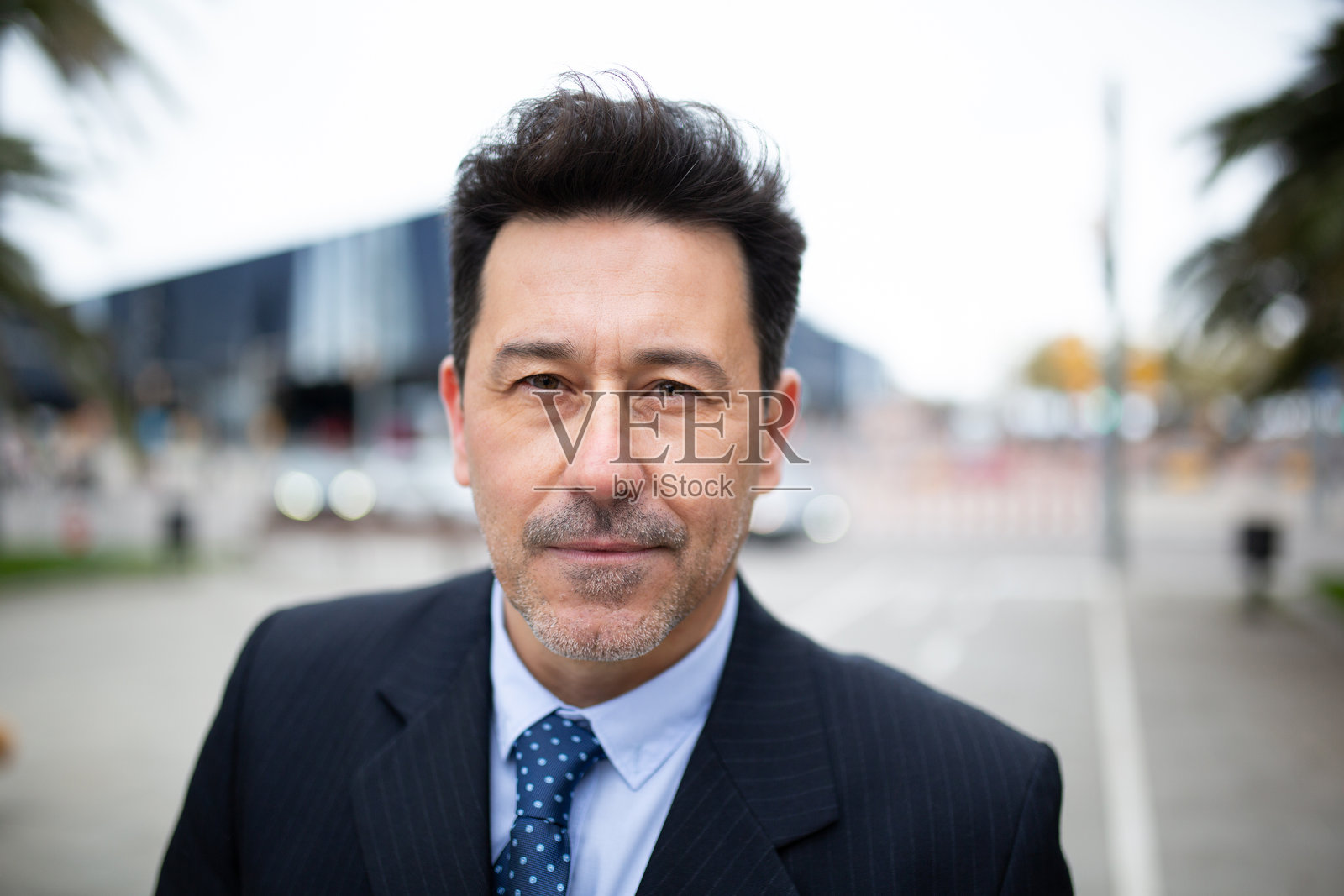 身穿西装的帅气老年男子在城市外站立照片摄影图片