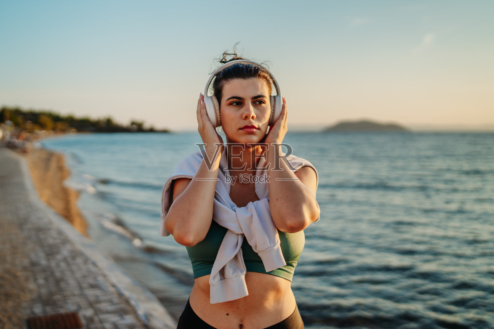 年轻的白人女性在日落时分的海滩上跑步或慢跑照片摄影图片