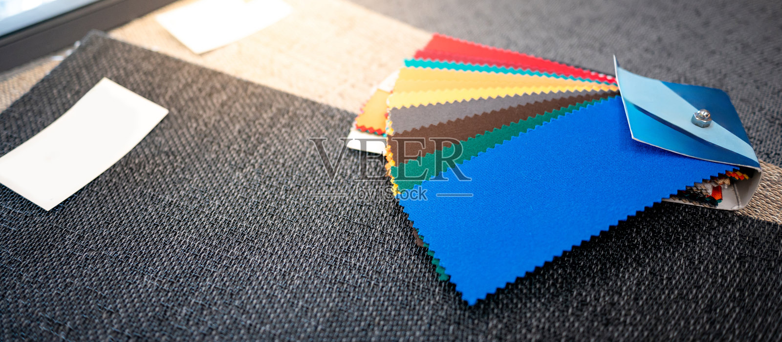 一组多彩的面料样本集合。家居装饰商店中的各种颜色和纹理样本面料。照片摄影图片