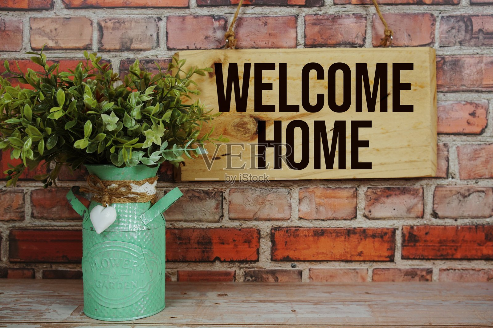 “欢迎回家”字样的木制标牌悬挂在旧砖墙背景上照片摄影图片