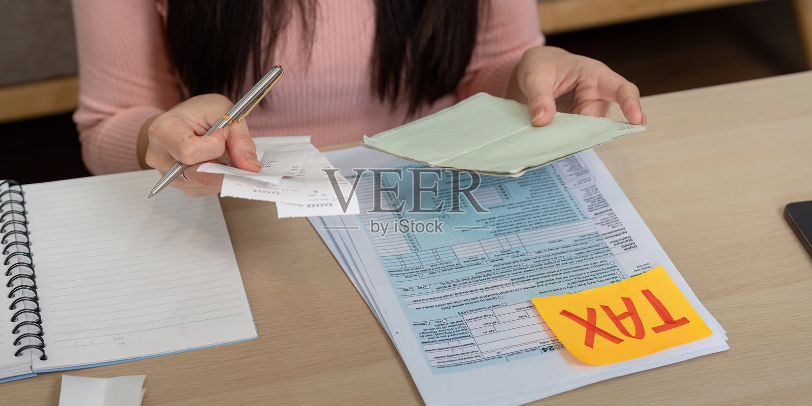 女性整理税务文件和收据,以进行财务规划和策略。照片摄影图片