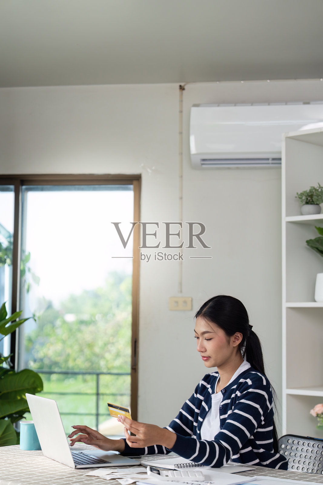 压力大的女性在家计算账单,管理财务和预算,手边有收据和笔记本电脑。照片摄影图片