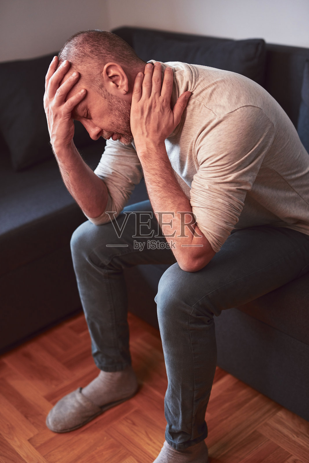 在家中感到颈部疼痛的男子。照片摄影图片