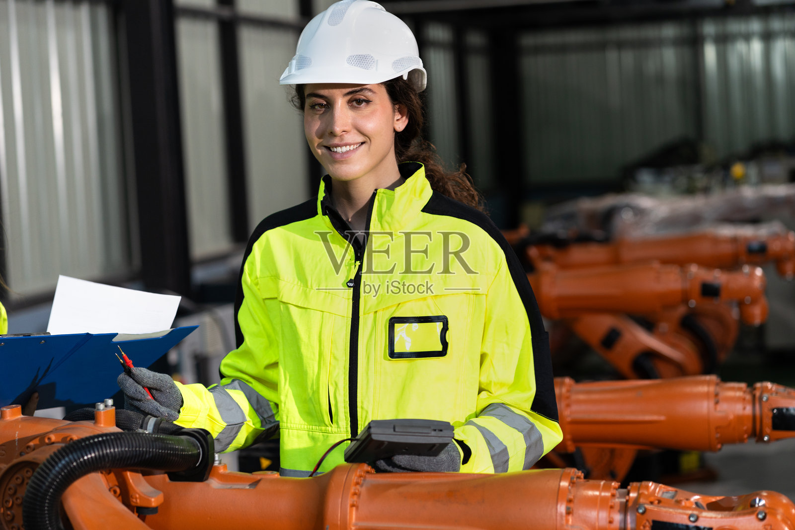 两名白人工程师在工厂检查和控制机械臂机器人照片摄影图片