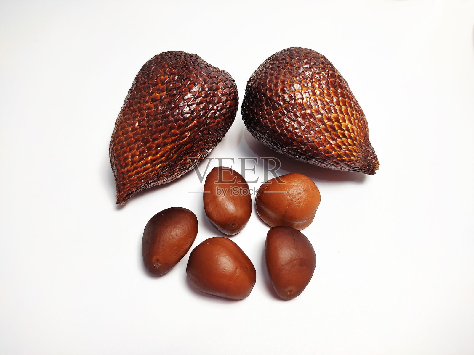 两颗沙拉克果(蛇果)和三颗种子的特写,背景为白色。照片摄影图片