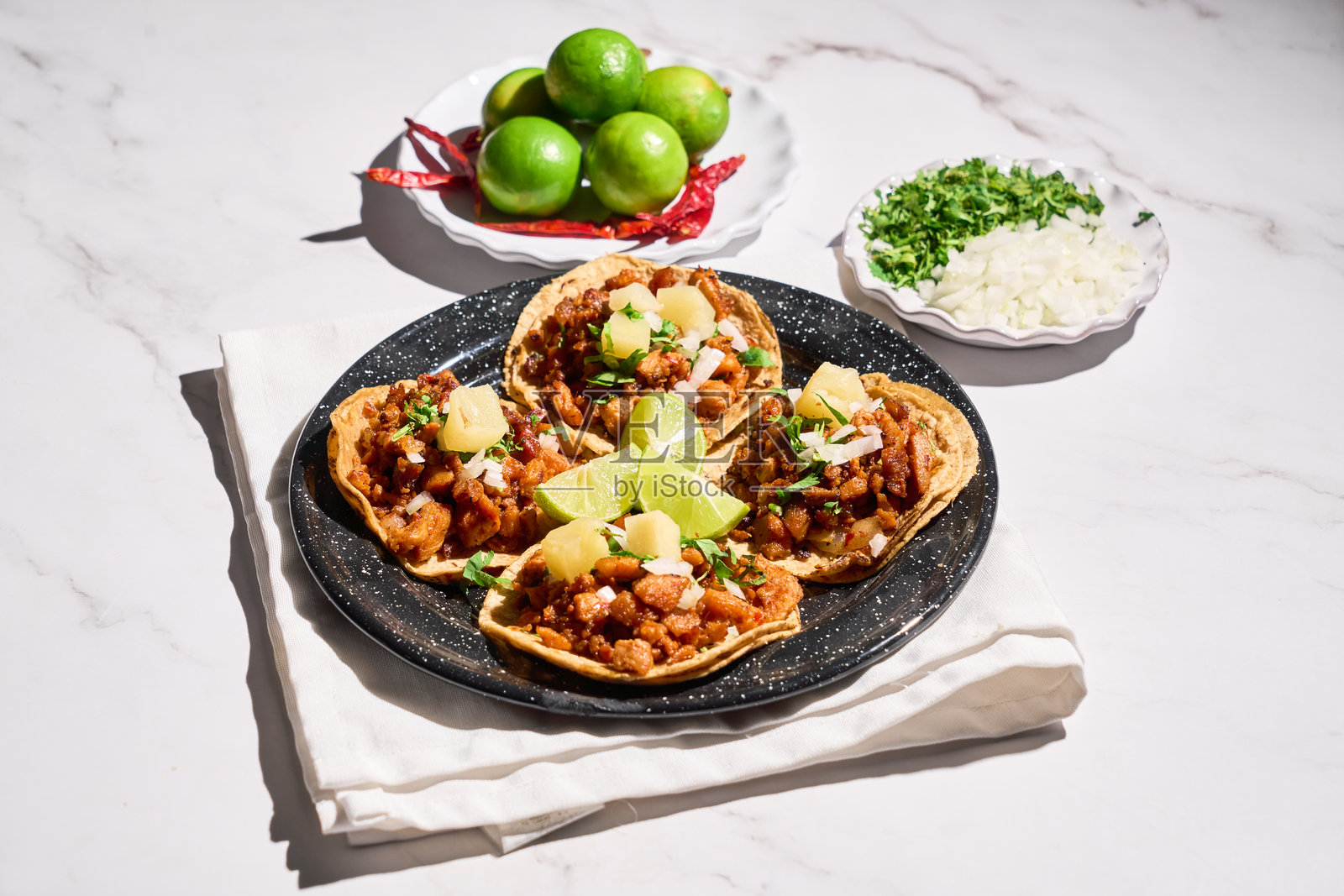 传统墨西哥塔可阿尔帕斯托,配新鲜青柠和莎莎酱,摆放在乡村风格的桌子上照片摄影图片