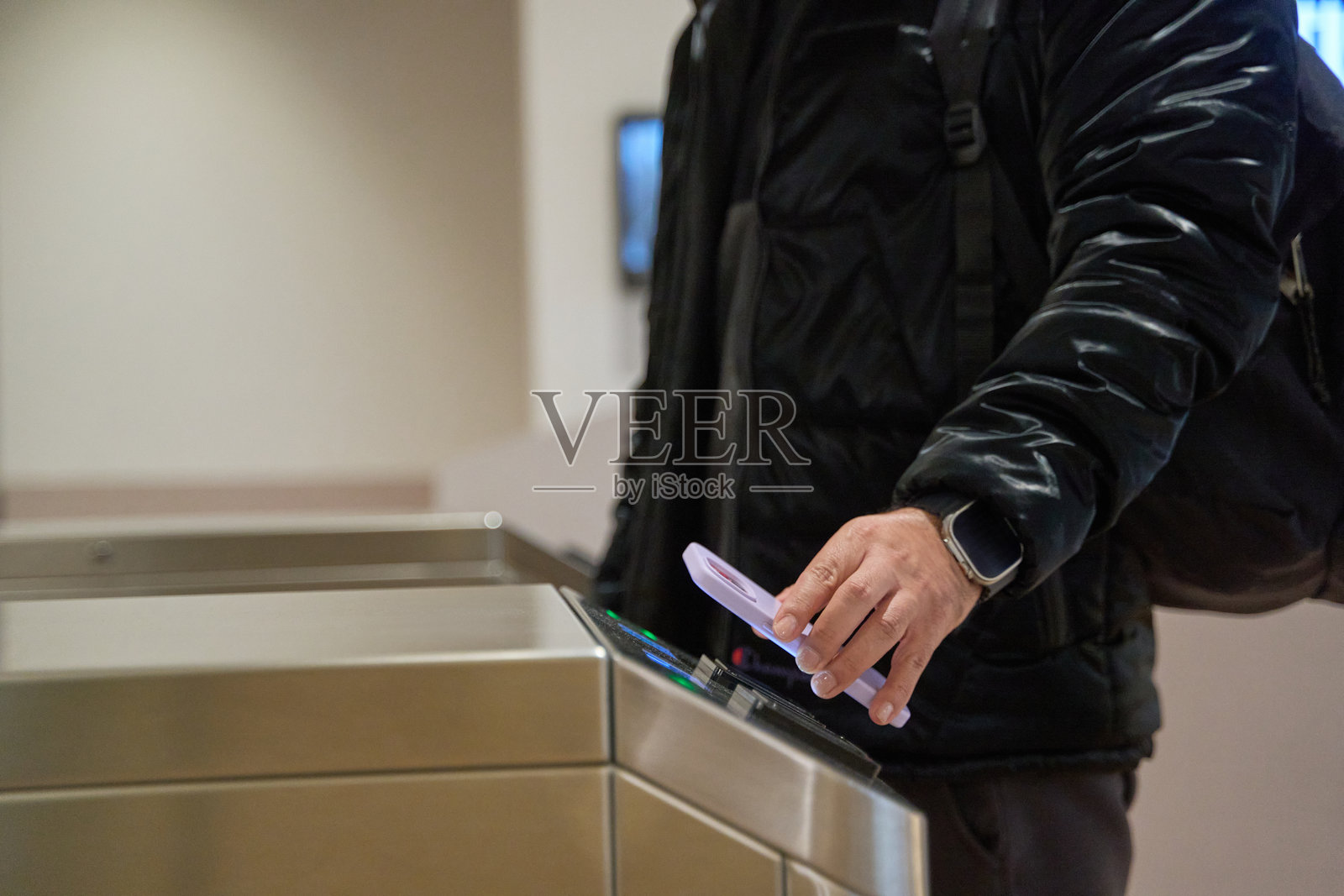 通勤者在闸机上使用智能手机进行无接触支付照片摄影图片