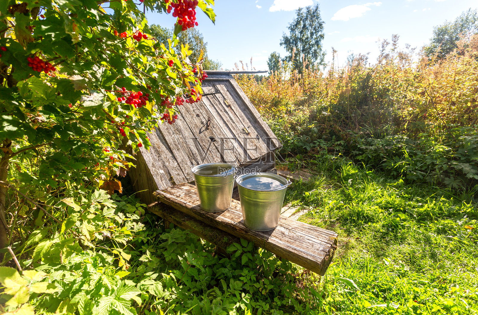 夏天的木制水井和装满水的水桶照片摄影图片