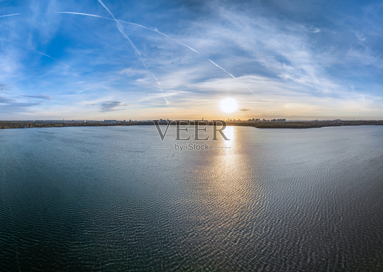 秋季森林在湖岸日落时分,远处城市的鸟瞰图照片摄影图片