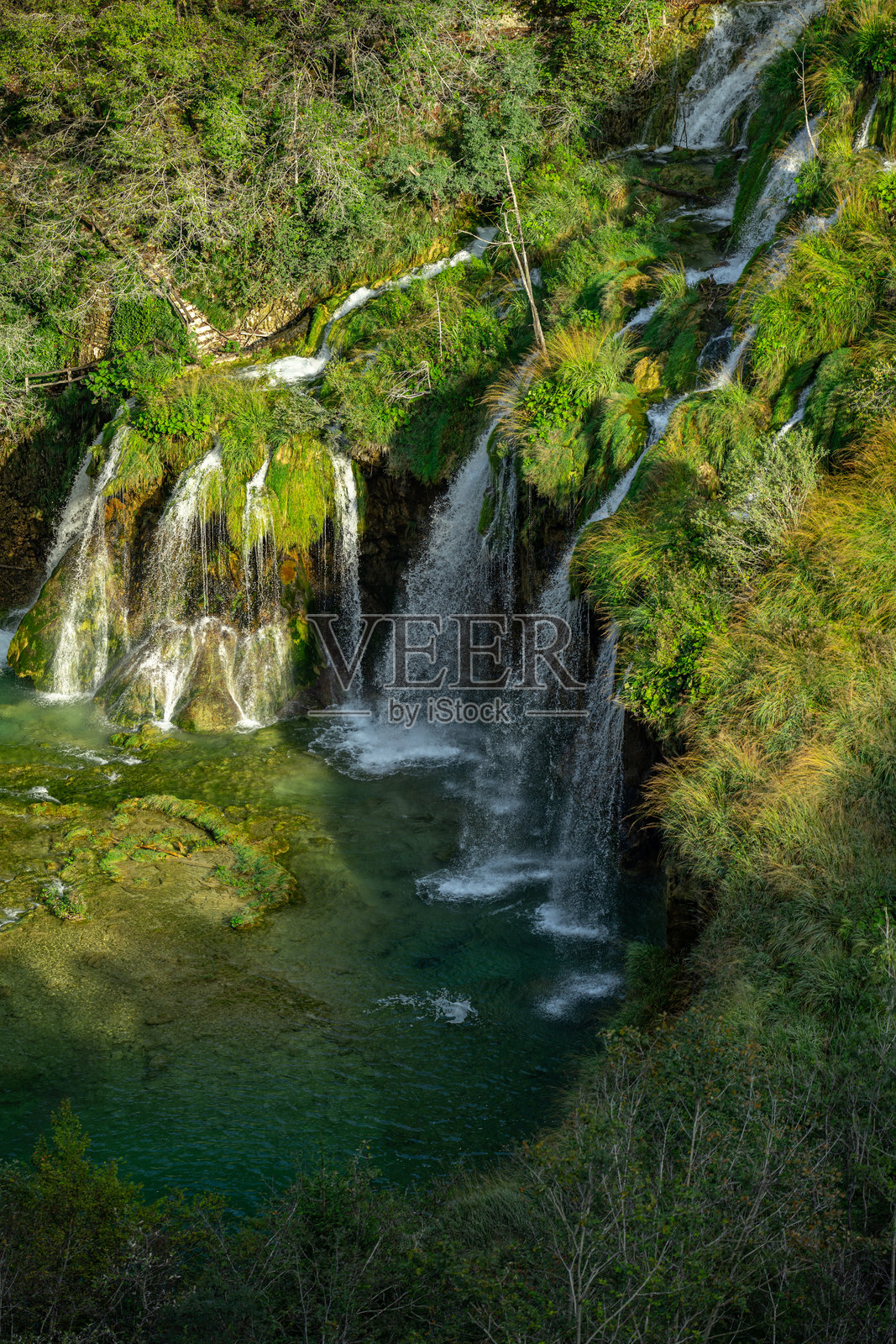 春天自然之美,森林中的壮观瀑布。瀑布和池塘。全景美丽的深林瀑布。绿树环绕的瀑布美景。宁静的瀑布水域。照片摄影图片