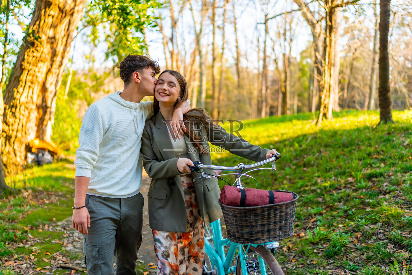 年轻情侣在公园里骑自行车,享受浪漫的散步。照片摄影图片