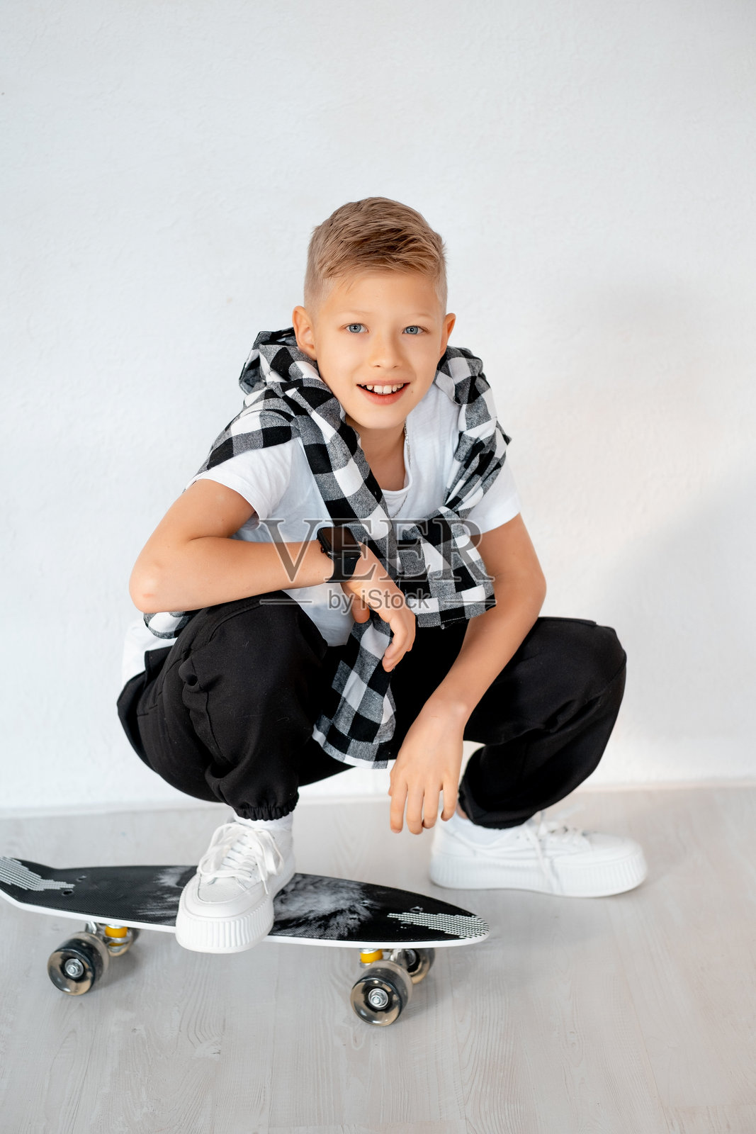 一个拿着滑板的少年,一个小男孩在白色背景下,一个空间和文本位置,一个正在玩运动的孩子照片摄影图片