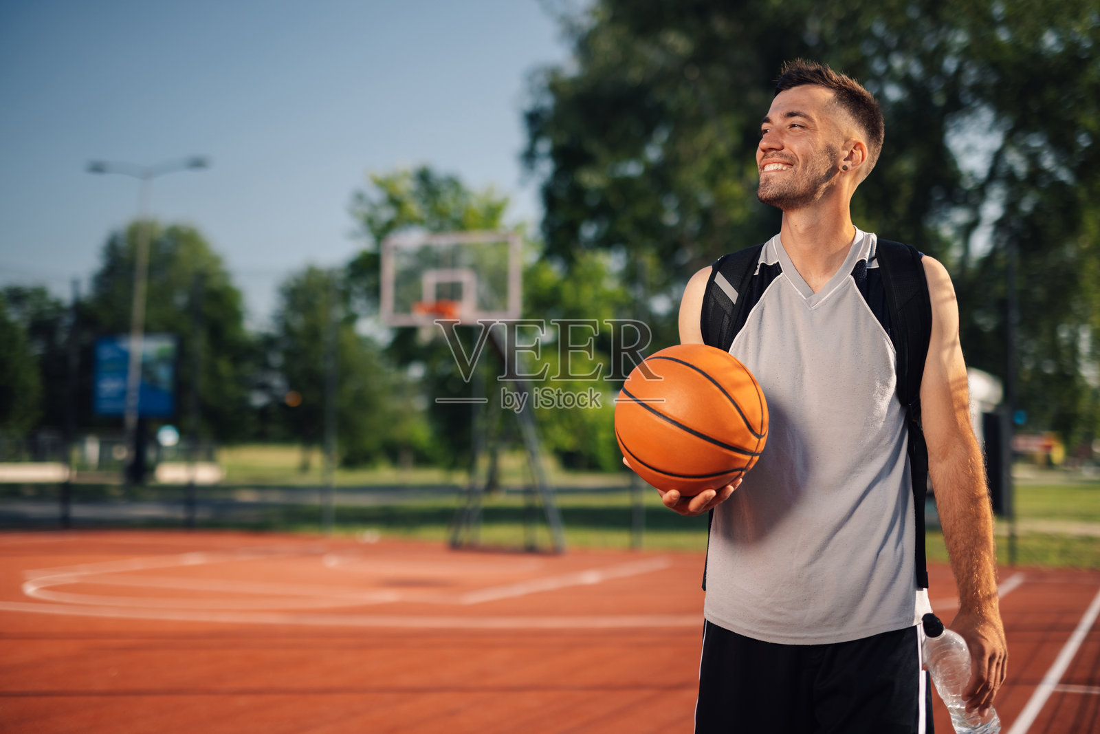 篮球运动员在训练结束后在球场上持球照片摄影图片