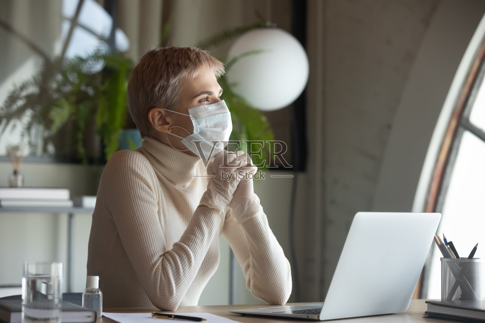 穿着防护装备的充满希望的女性员工在祈祷照片摄影图片