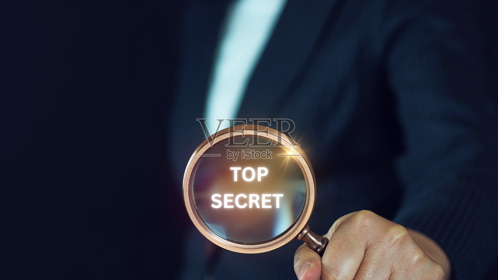 私人侦探手持放大镜,专注于机密信封照片摄影图片