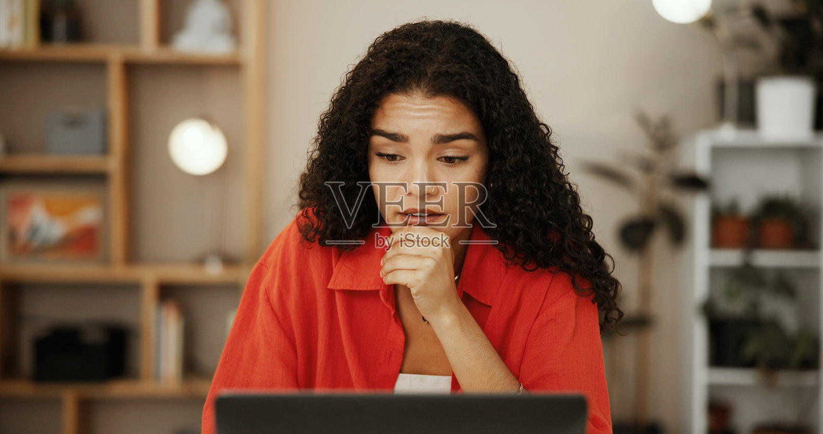 困惑的女性在家办公,使用笔记本电脑思考研究、规划和电子商务销售反馈。担忧、想法和与个人有关的负面在线评论的代发小型企业。照片摄影图片