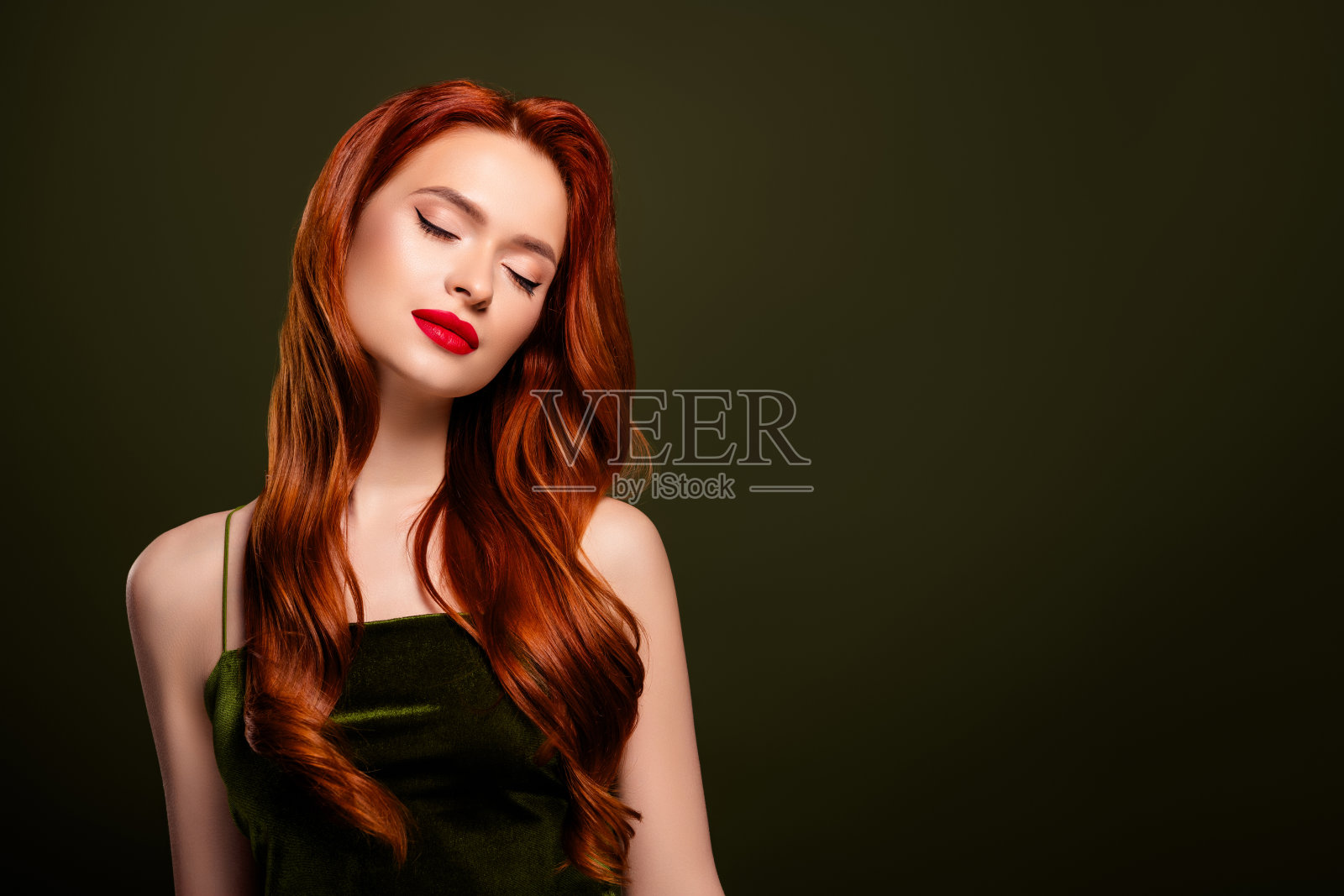 美丽迷人的女士闭着眼睛,摆姿势享受夜总会派对活动,背景为卡其色。照片摄影图片