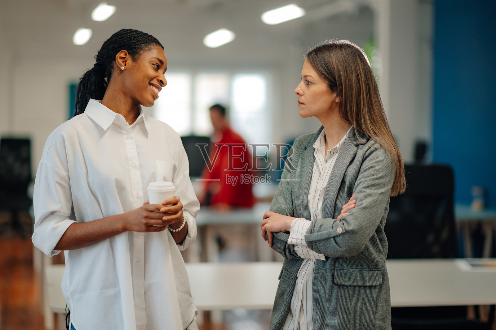 两位女商人在现代办公室的咖啡休息时间交谈照片摄影图片