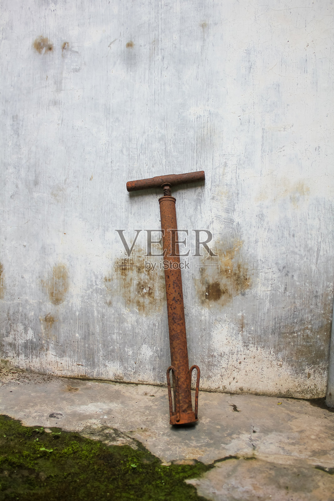 旧的生锈水泵靠近混凝土墙照片摄影图片