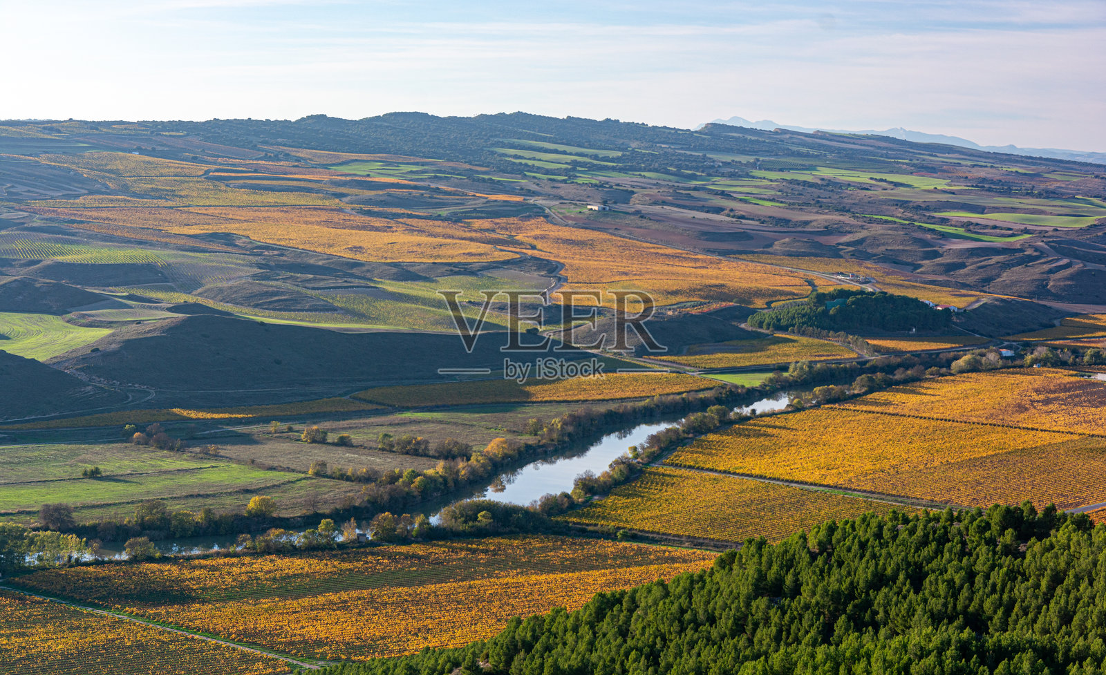 农田和葡萄园环绕着一条贯穿景观的河流照片摄影图片