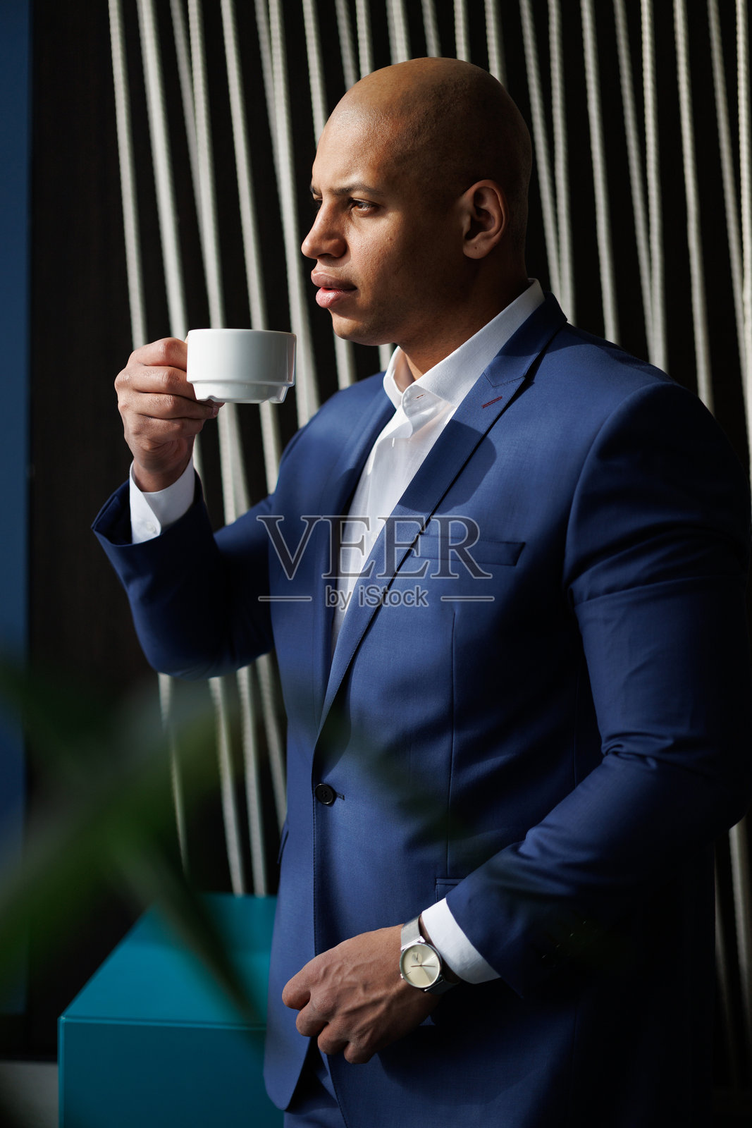 非裔美国商人在酒店大堂里拿着咖啡杯照片摄影图片