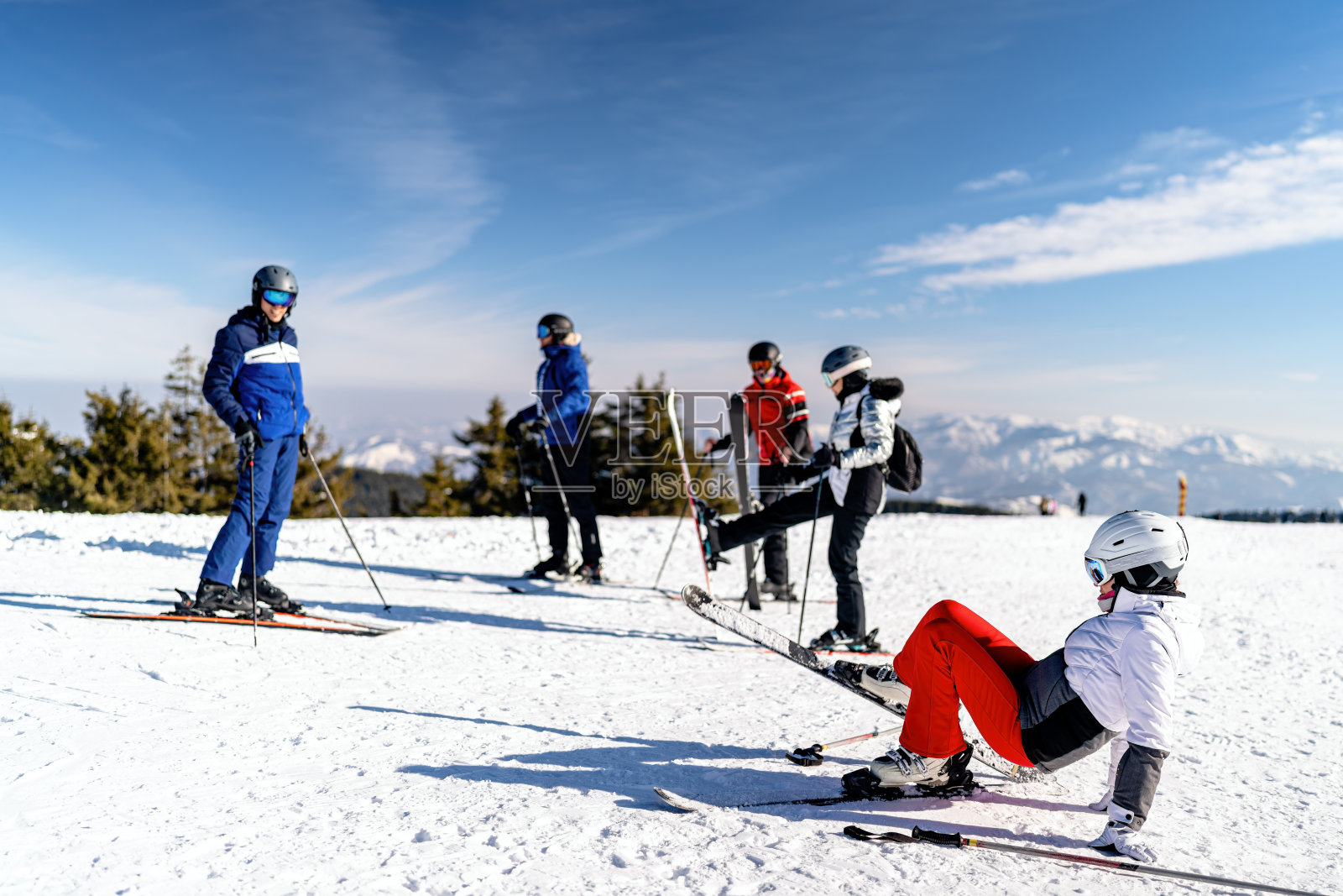 一群滑雪者在阳光明媚的雪坡上休息照片摄影图片