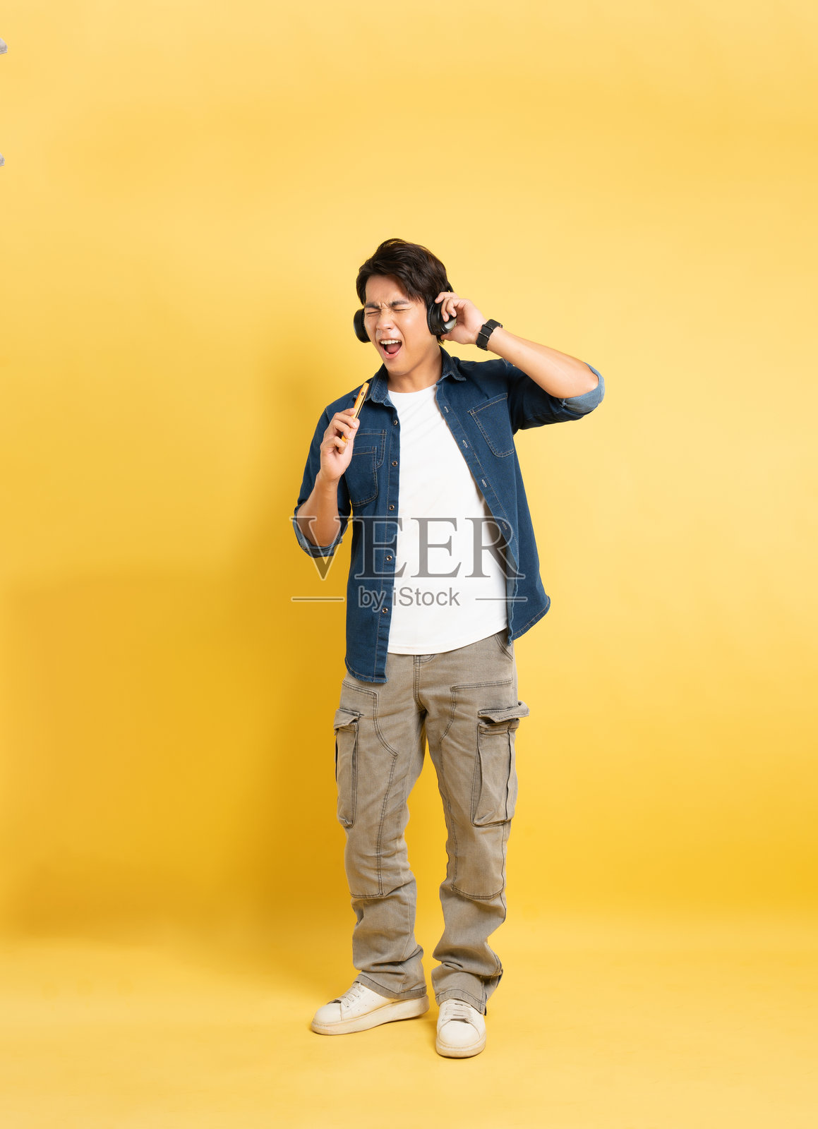 亚洲男子在黄色背景前摆姿势的肖像照片摄影图片