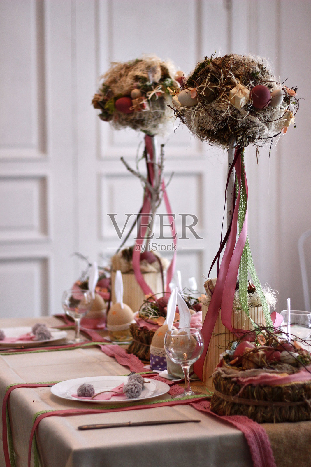 复活节桌面布置,配有圆形修剪树和粉色丝带照片摄影图片