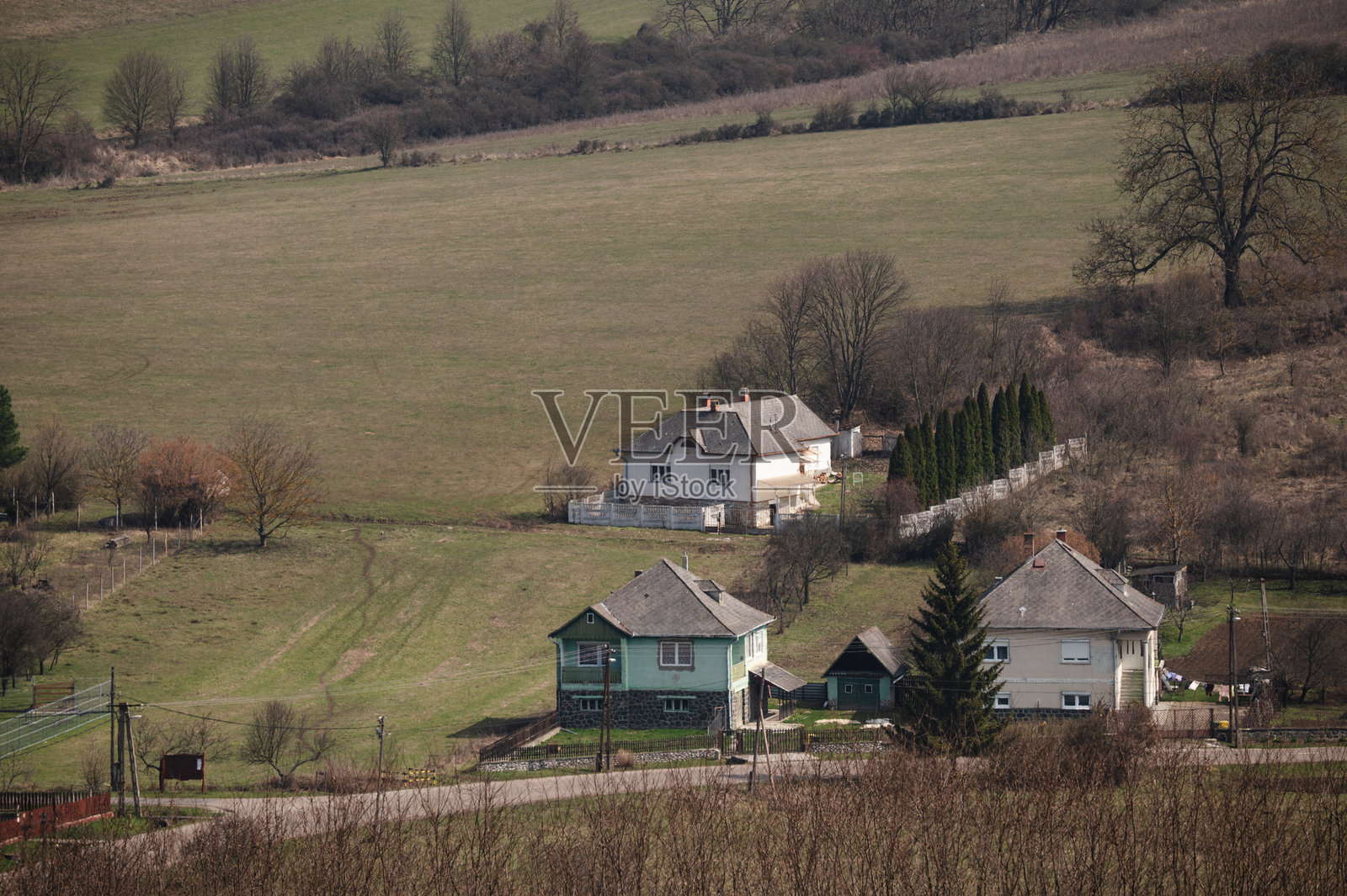 被山丘环绕的乡村山谷中的房屋照片摄影图片