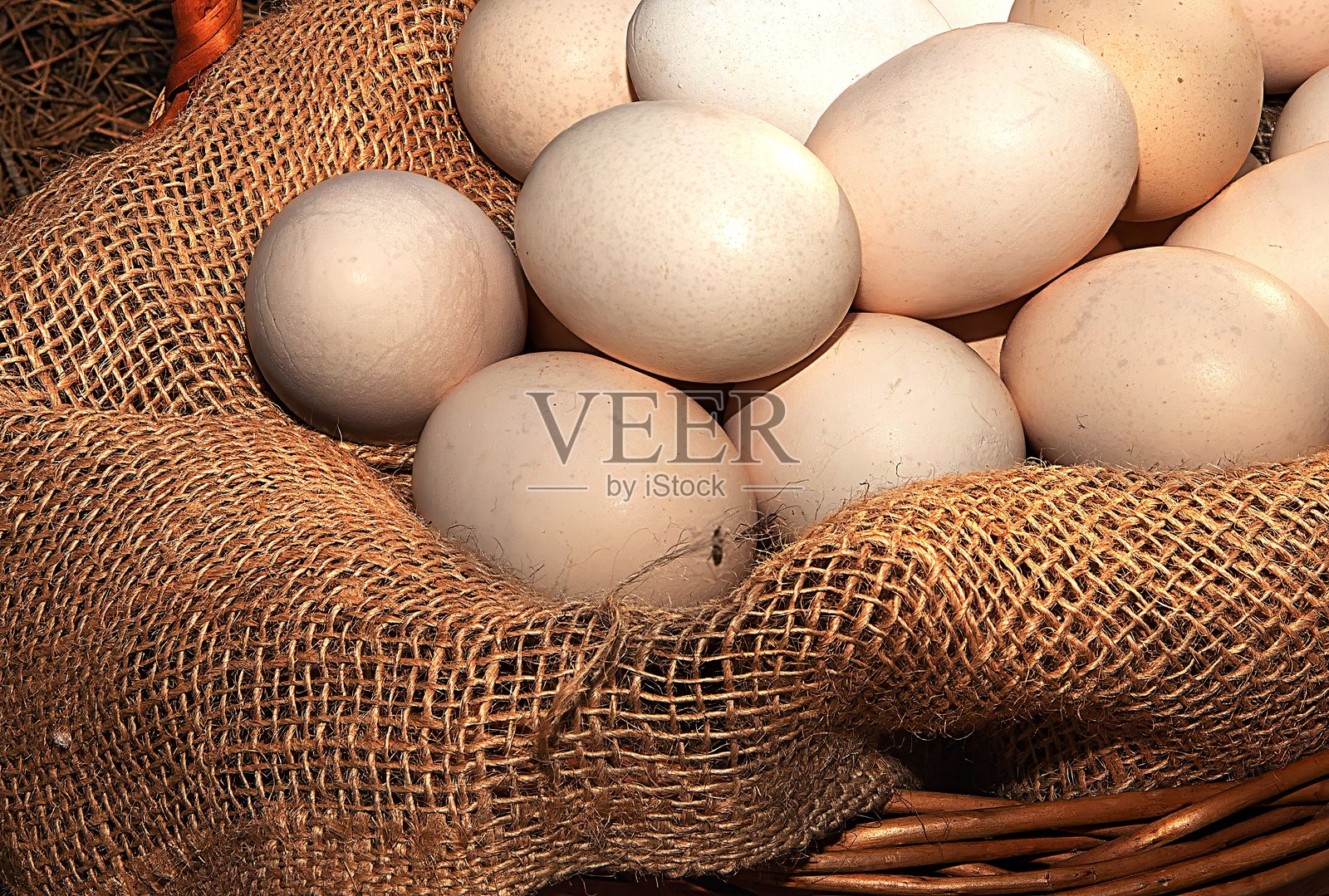 温暖阳光下,柳条篮中的新鲜鸡蛋放在麻布上 - 自然农产品照片摄影图片