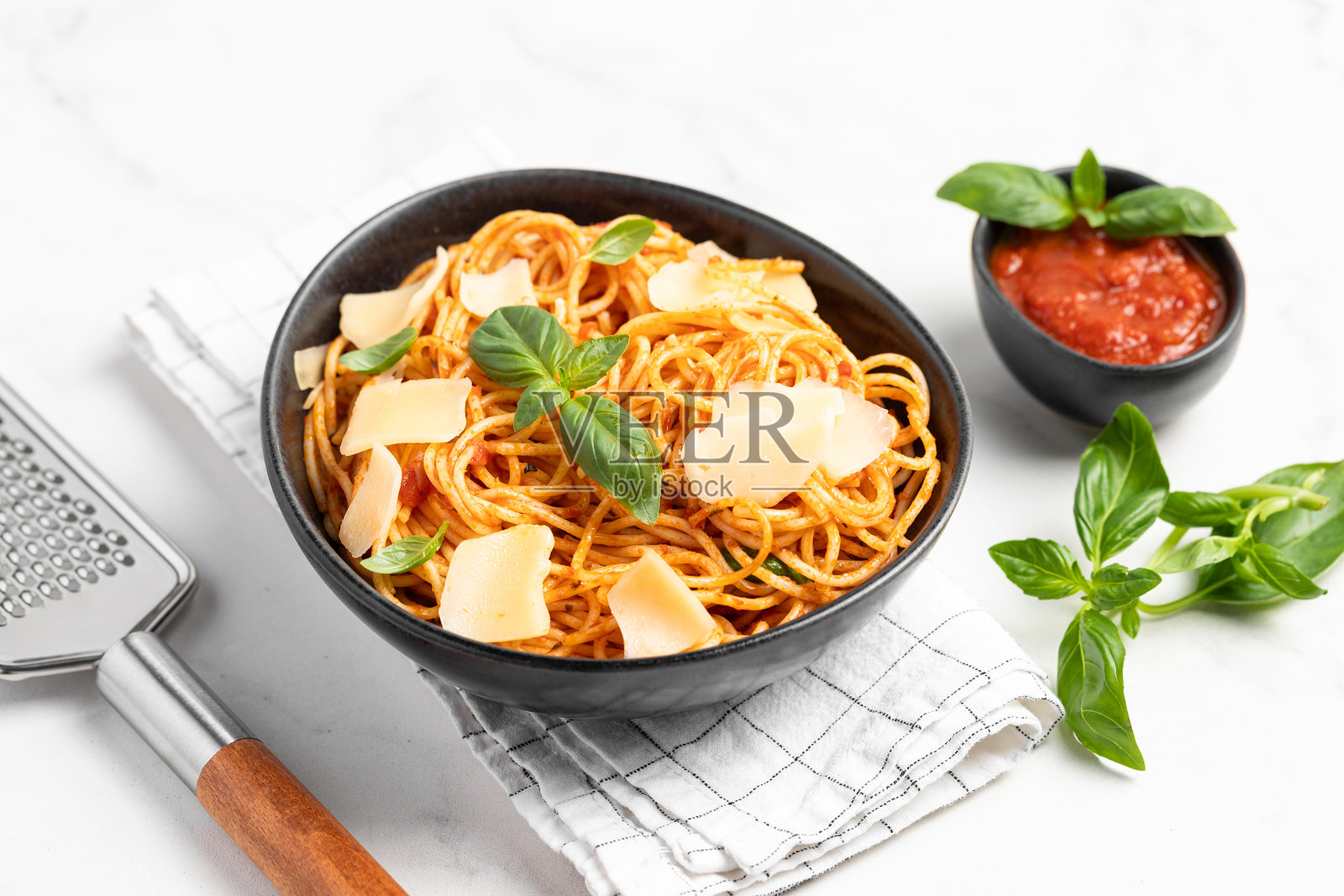 意大利面配番茄酱、帕尔马干酪和罗勒,浅色背景照片摄影图片