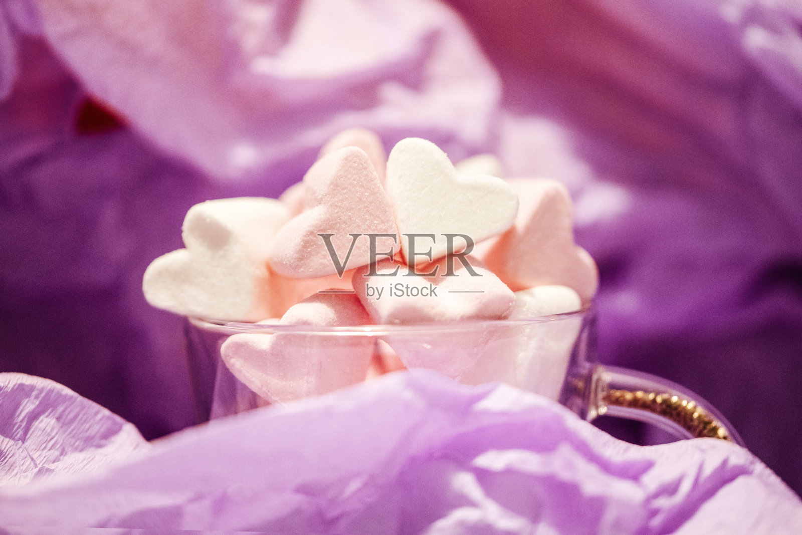 紫色背景下玻璃杯中的心形情人节棉花糖照片摄影图片