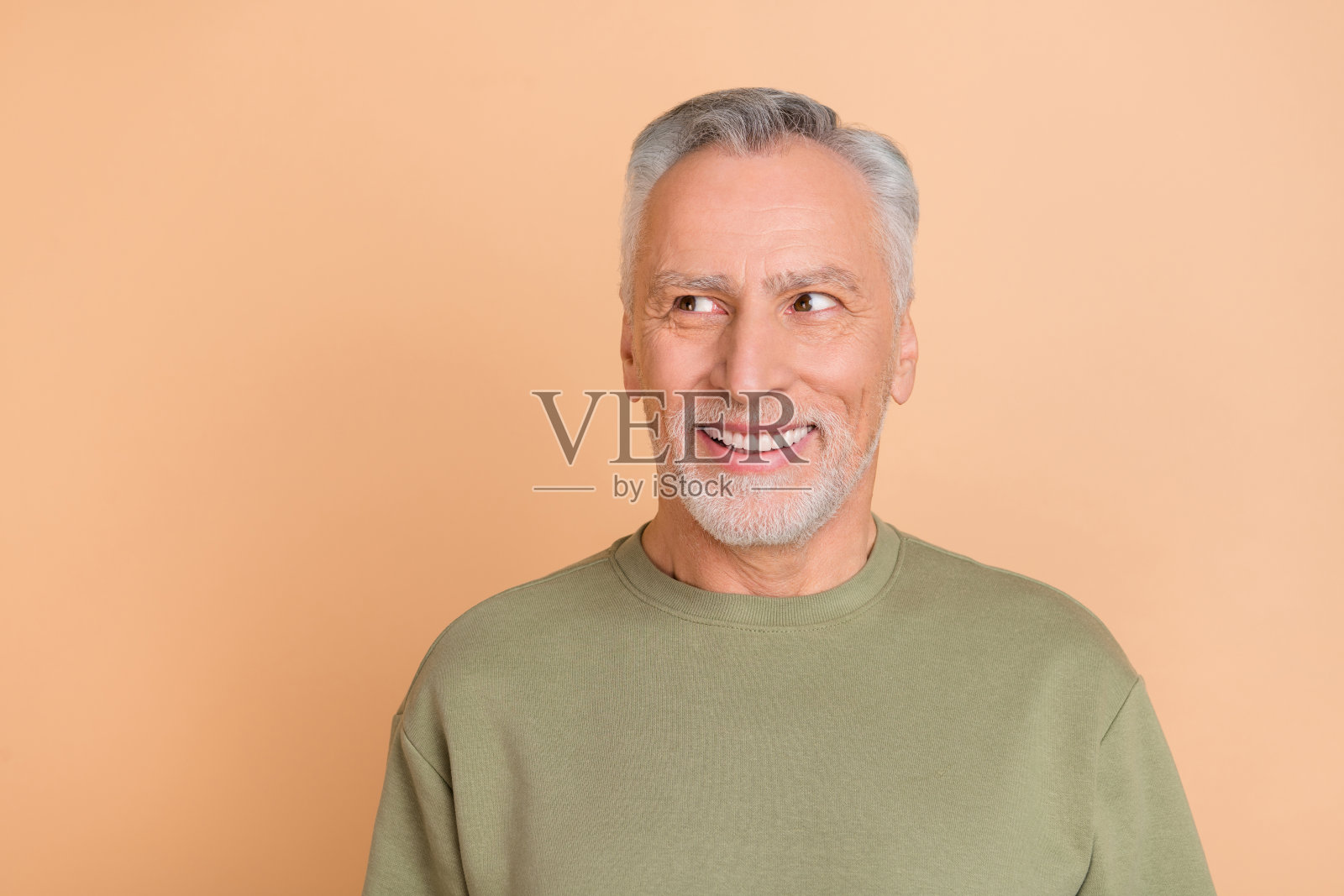 成熟快乐的男人好奇地看着空白空间,灵感迸发,背景为米色。照片摄影图片