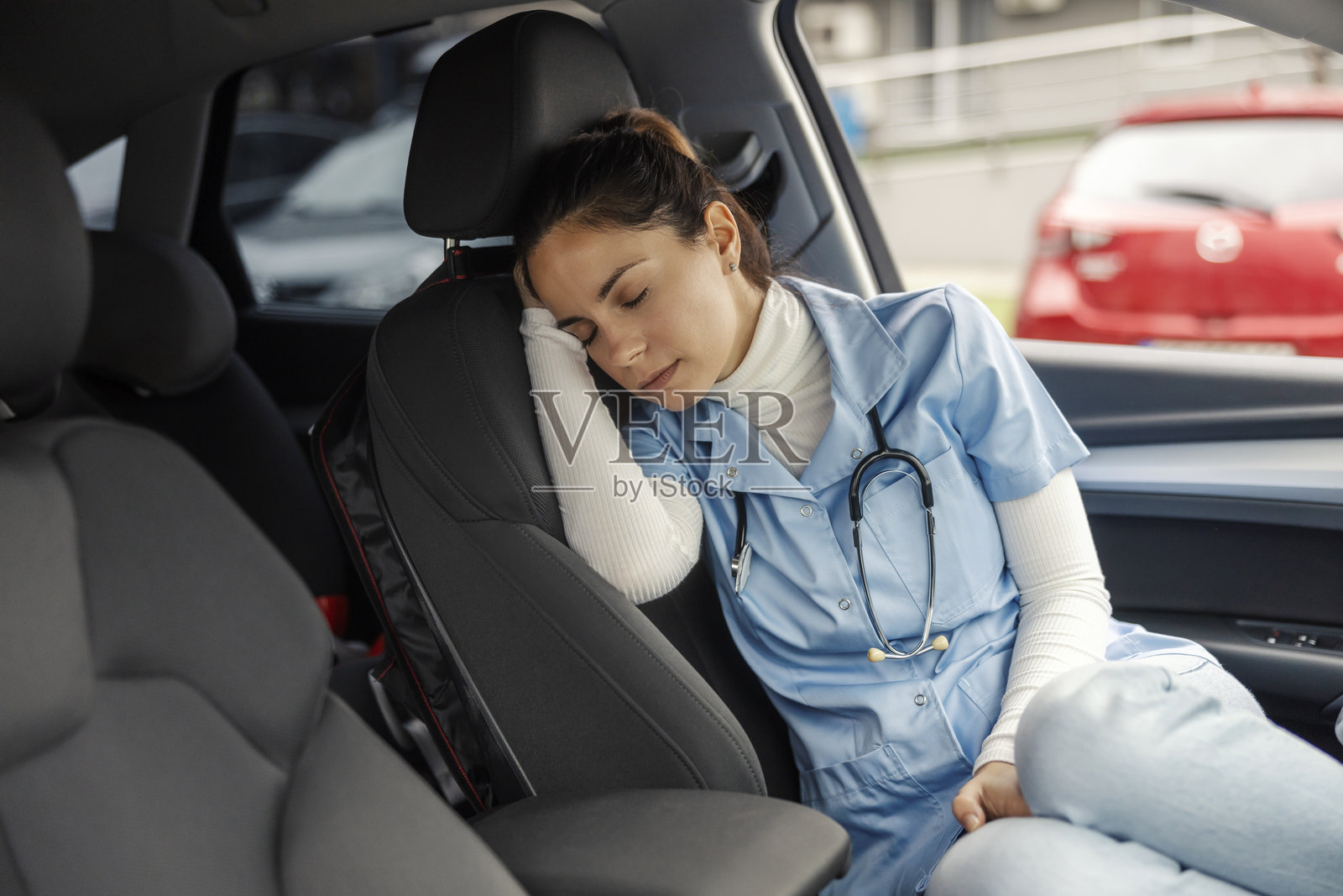 疲惫的护士在医院夜班后在车里睡觉。照片摄影图片