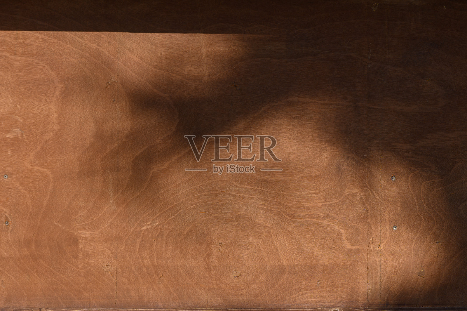 自然光在有纹理的木质表面上投射出阴影,营造出宁静和艺术奇观的感觉,置身于宁静的环境中。照片摄影图片