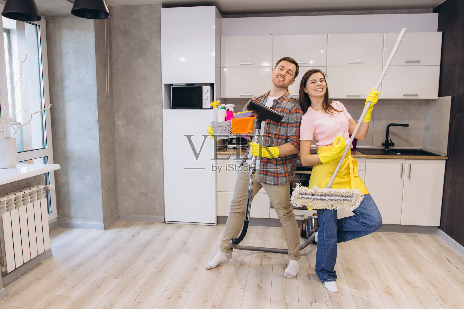 一对情侣在清洁厨房地板时享受乐趣照片摄影图片