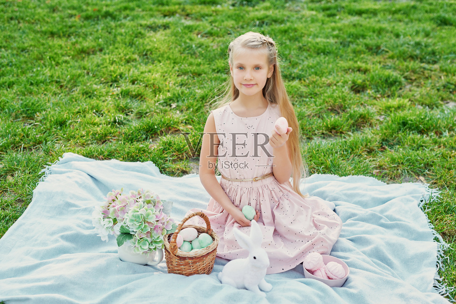 快乐的复活节兔子。孩子在户外玩得很开心。小孩在绿草地上与鸡蛋和兔子玩耍。春季假期概念。复活节贺卡模板。复活节小女孩与兔子和鸡蛋。照片摄影图片