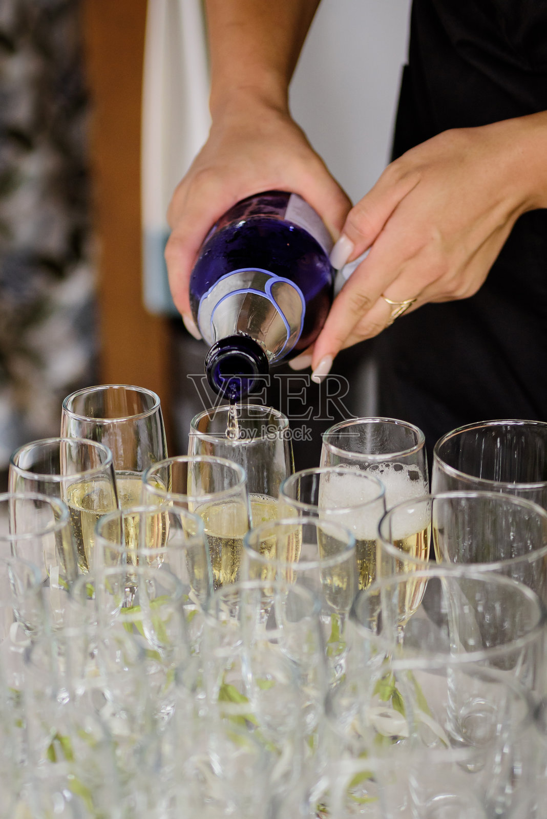 服务员将香槟倒入酒杯中照片摄影图片