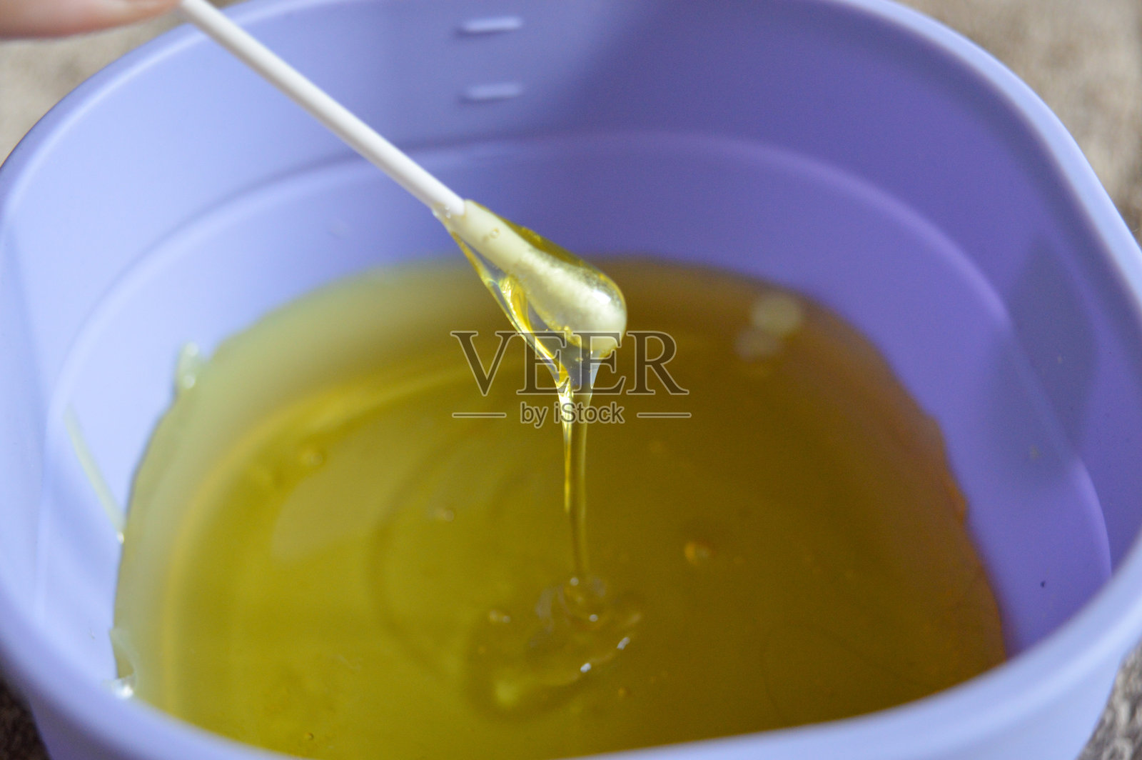 紫色蜡烛加热器,内含融化的黄色蜡,白色脱毛条,家庭专业脱毛护理,美容护肤教程,美容院水疗服务,脱毛套件,脱毛配件照片摄影图片