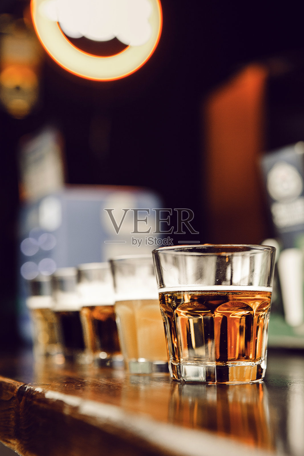 精酿啤酒整齐地摆放在酒吧光滑的吧台上照片摄影图片