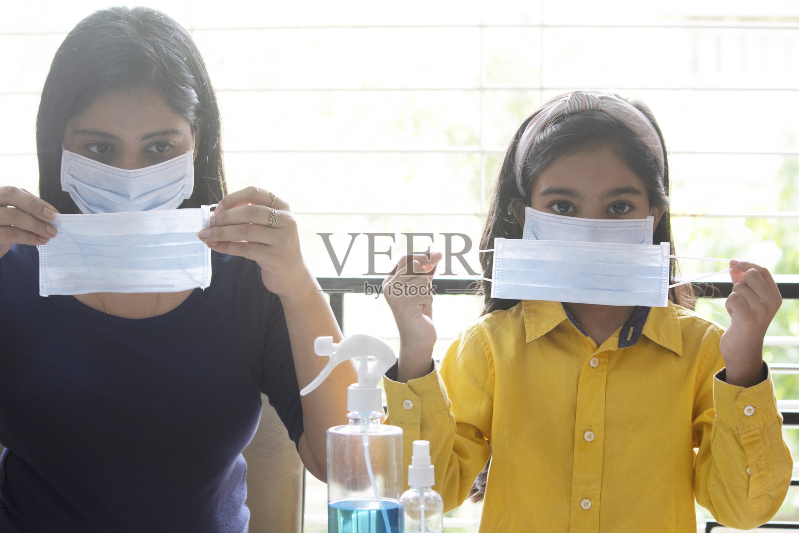 母亲和女儿戴着双层口罩采取额外的防病毒措施照片摄影图片