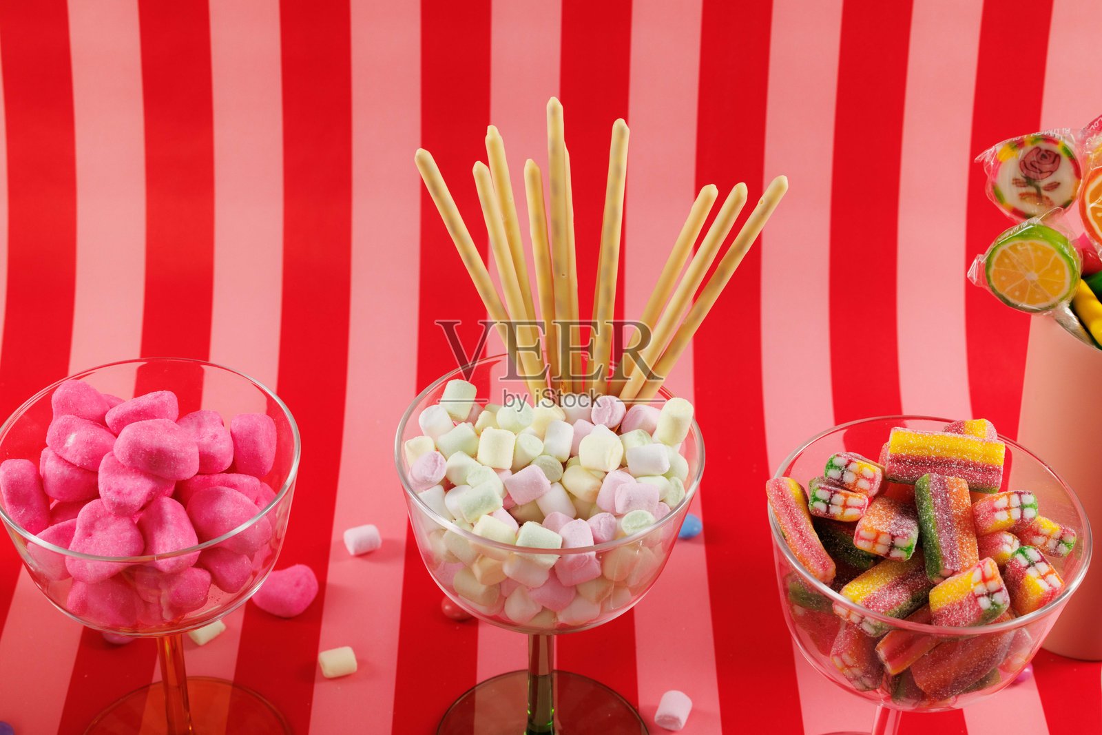 红色和粉色条纹背景上的糖果特写。酸甜糖果。照片摄影图片