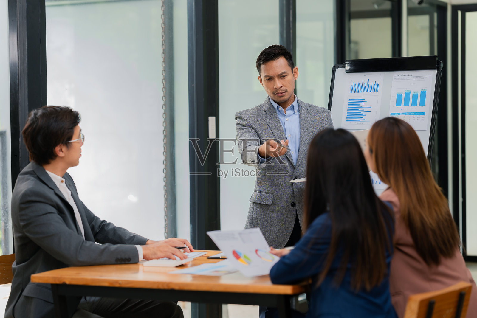 积极的商人带领经理召开商务会议。演讲中使用电视展示统计数据,利用图表和图形制定有效策略。照片摄影图片