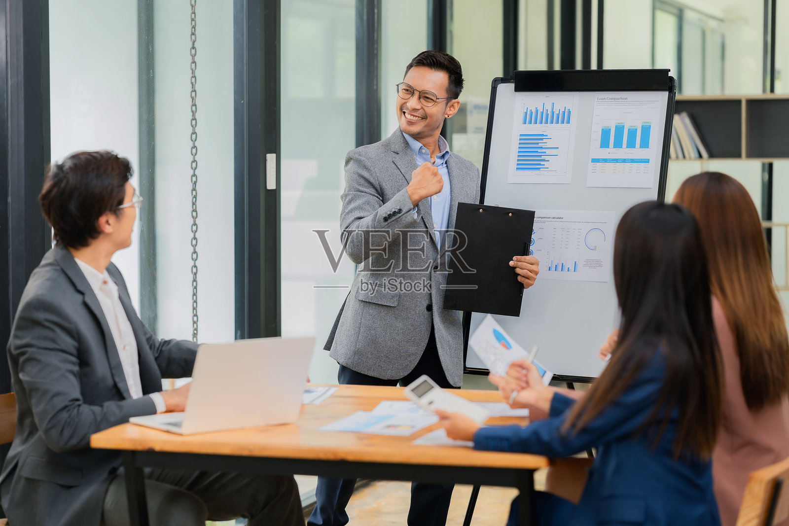 一群成功的企业在办公室举行ESG会议庆祝他们的成功,展示公司增长和营销策略的信息。同事们热烈鼓掌欢呼。照片摄影图片