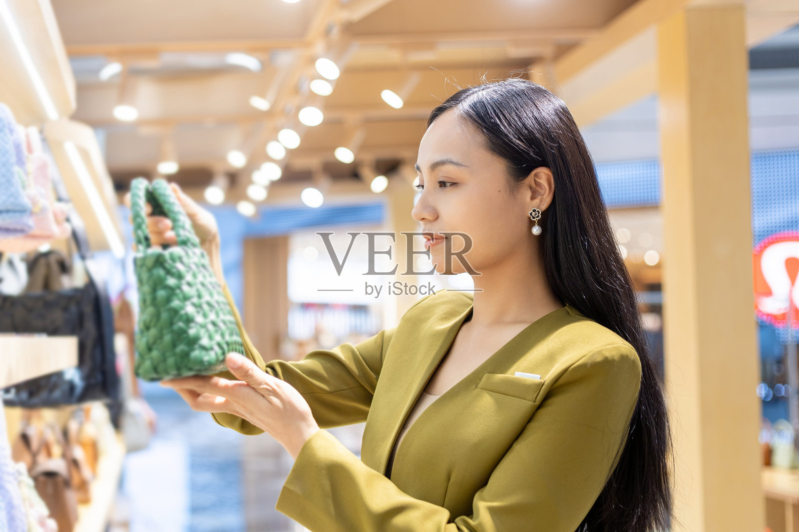 年轻的中国女性在挑选手提包照片摄影图片