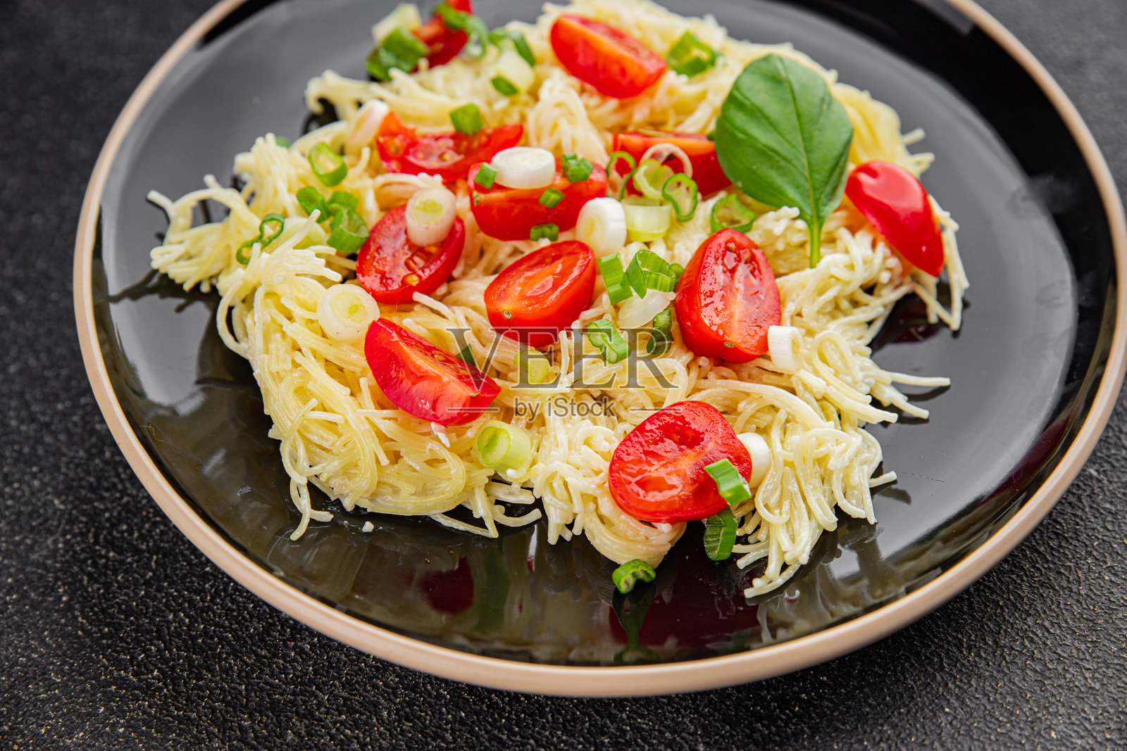 新鲜美味的意大利面配番茄、细面条和蔬菜,餐桌上的乡村风格美食,俯视图,留白空间照片摄影图片