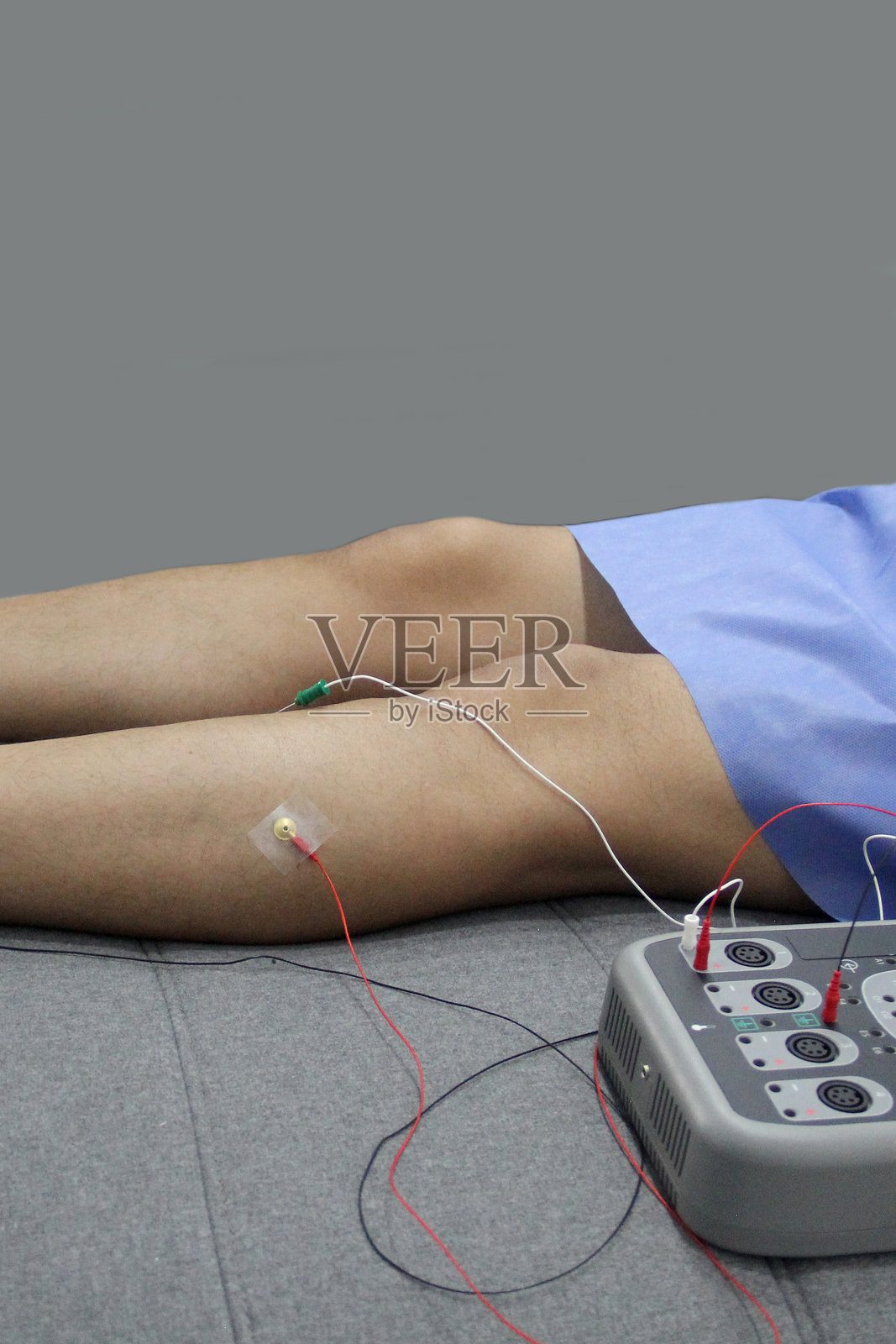 神经科医生办公室中成年患者腿部的肌电图和体感诱发电位检测照片摄影图片